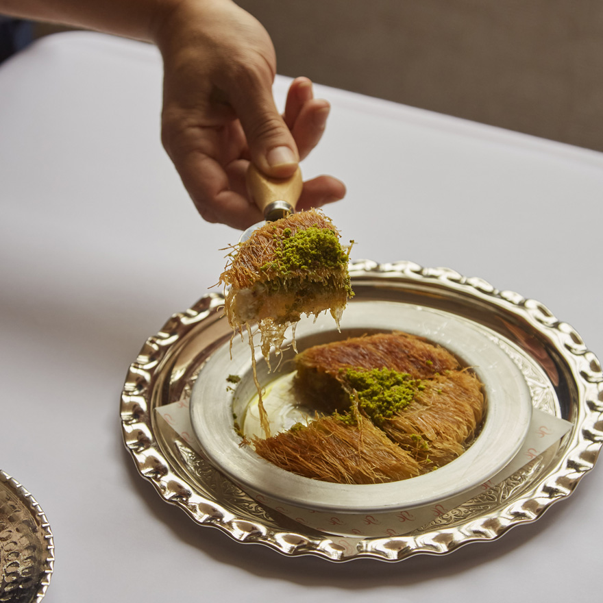 A hand serving a dessert at Leydi restaurant, Hyde London